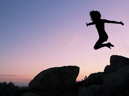 Image of woman jumping off rocks, symbolzing the jump organizations take into social media marketing plans.