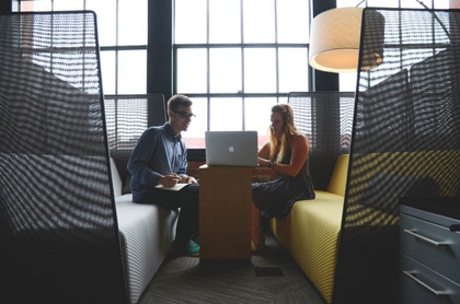 Image of two people in office working to understand a client's needs.