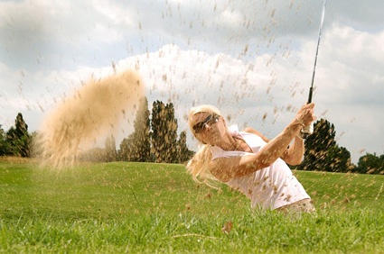 Image of woman golfing, hitting out of sand trap. Avoid paid search advertising traps to build successful campaigns.