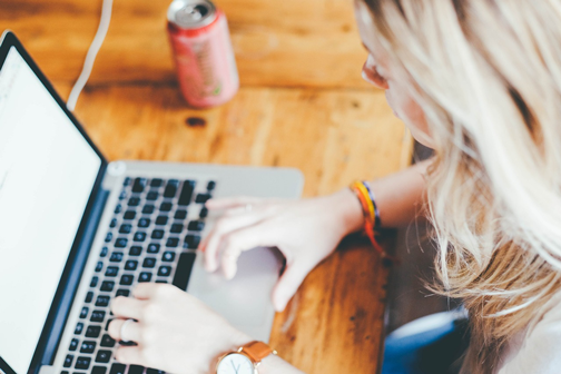 Image of woman using computer to engage with a business website.